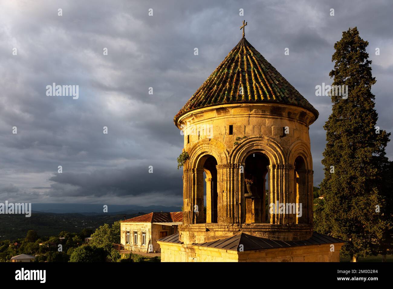 Belfry du monastère de la Gelati (clocher), complexe monastique médiéval près de Kutaisi, Géorgie fondé par le roi David IV, vue sur le coucher du soleil avec des nuages sombres Banque D'Images