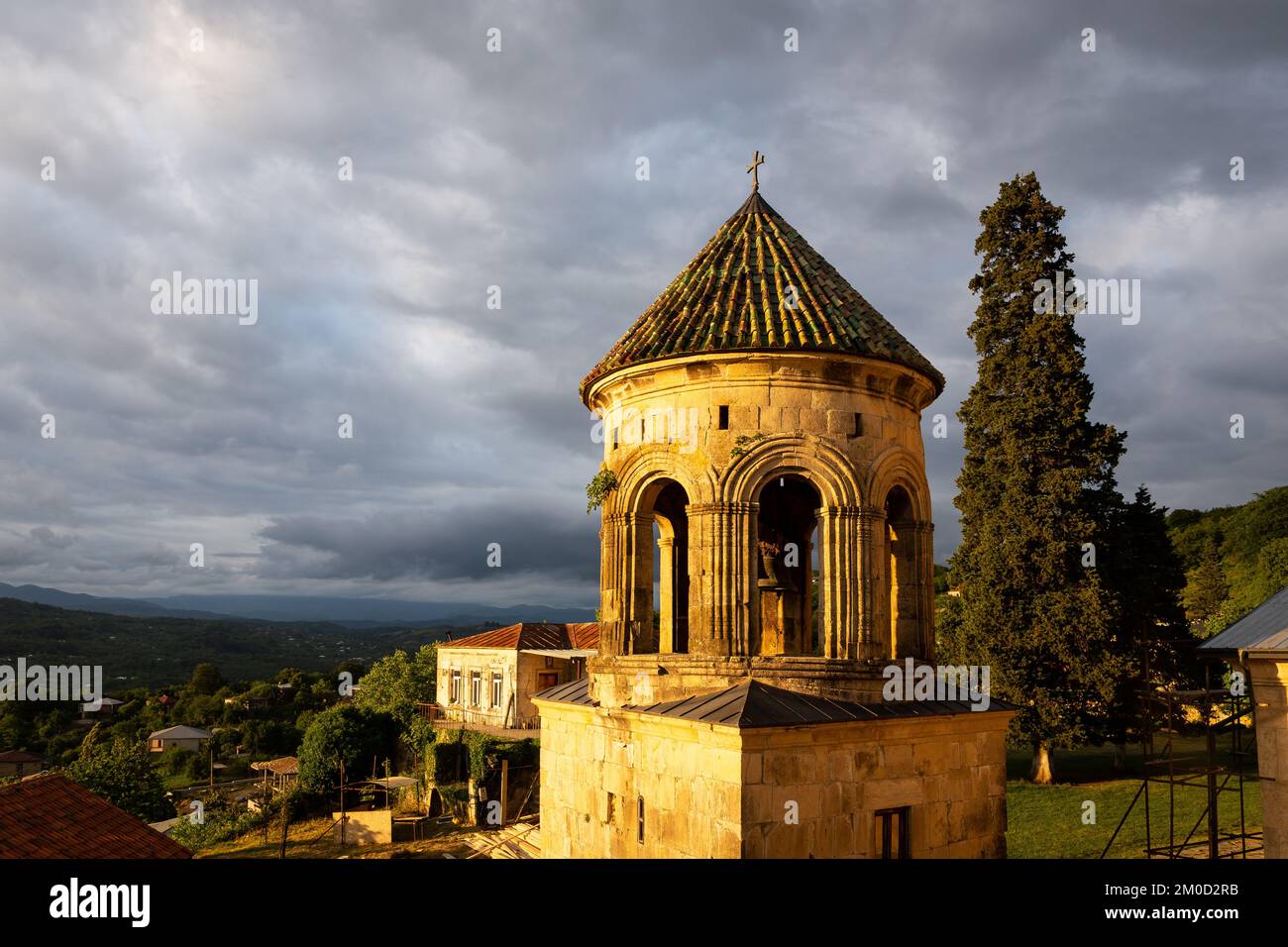 Belfry du monastère de la Gelati (clocher), complexe monastique médiéval près de Kutaisi, Géorgie fondé par le roi David IV, vue sur le coucher du soleil avec des nuages sombres Banque D'Images