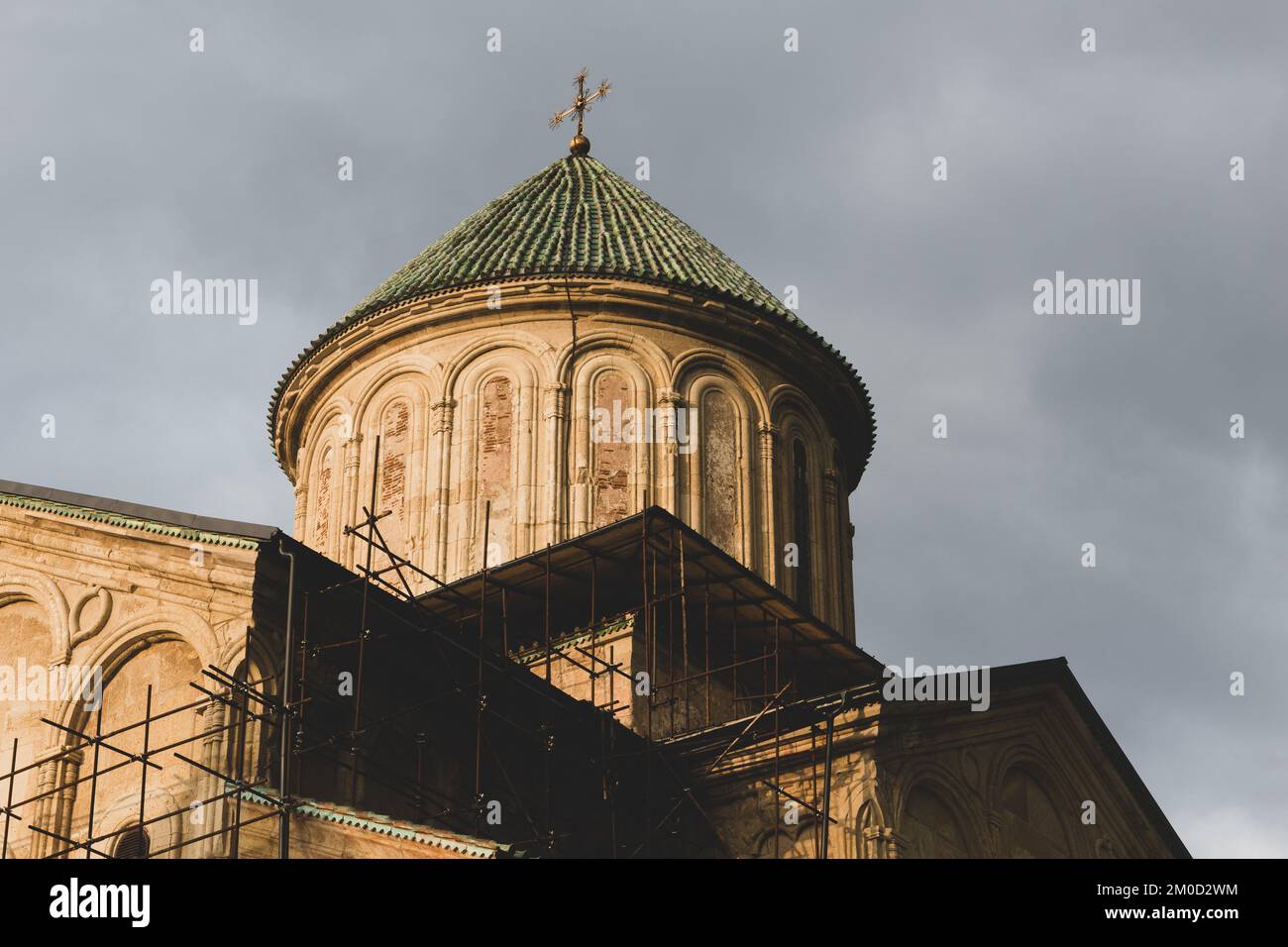 Belfry du monastère de la Gelati (clocher), complexe monastique médiéval près de Kutaisi, Géorgie fondé par le roi David IV, murs en pierre avec toit de tuiles vertes, sombre Banque D'Images