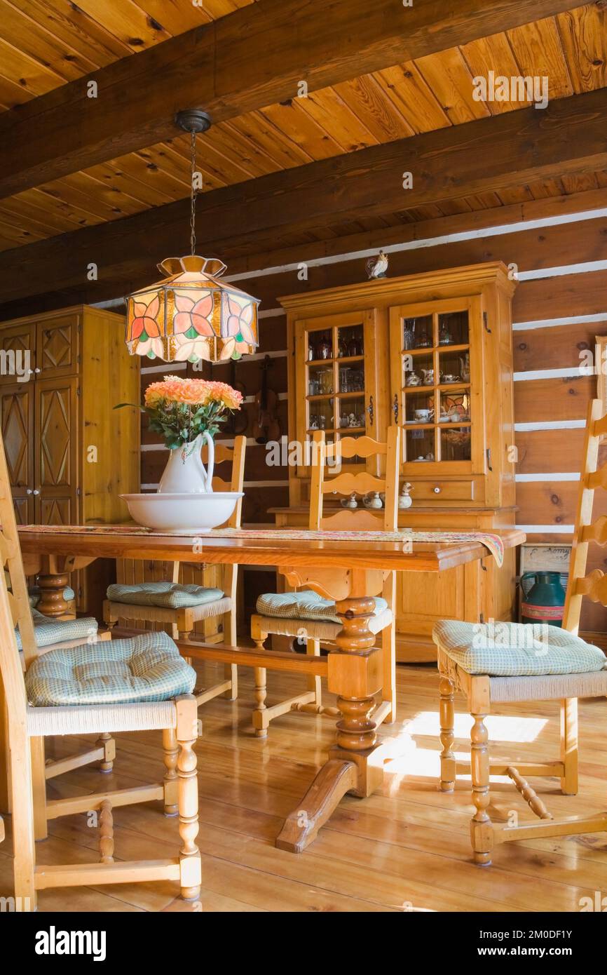 Chaises en bois de pin, table et meubles dans la salle à manger à l'intérieur de la maison en rondins de style cottage Canadiana. Banque D'Images