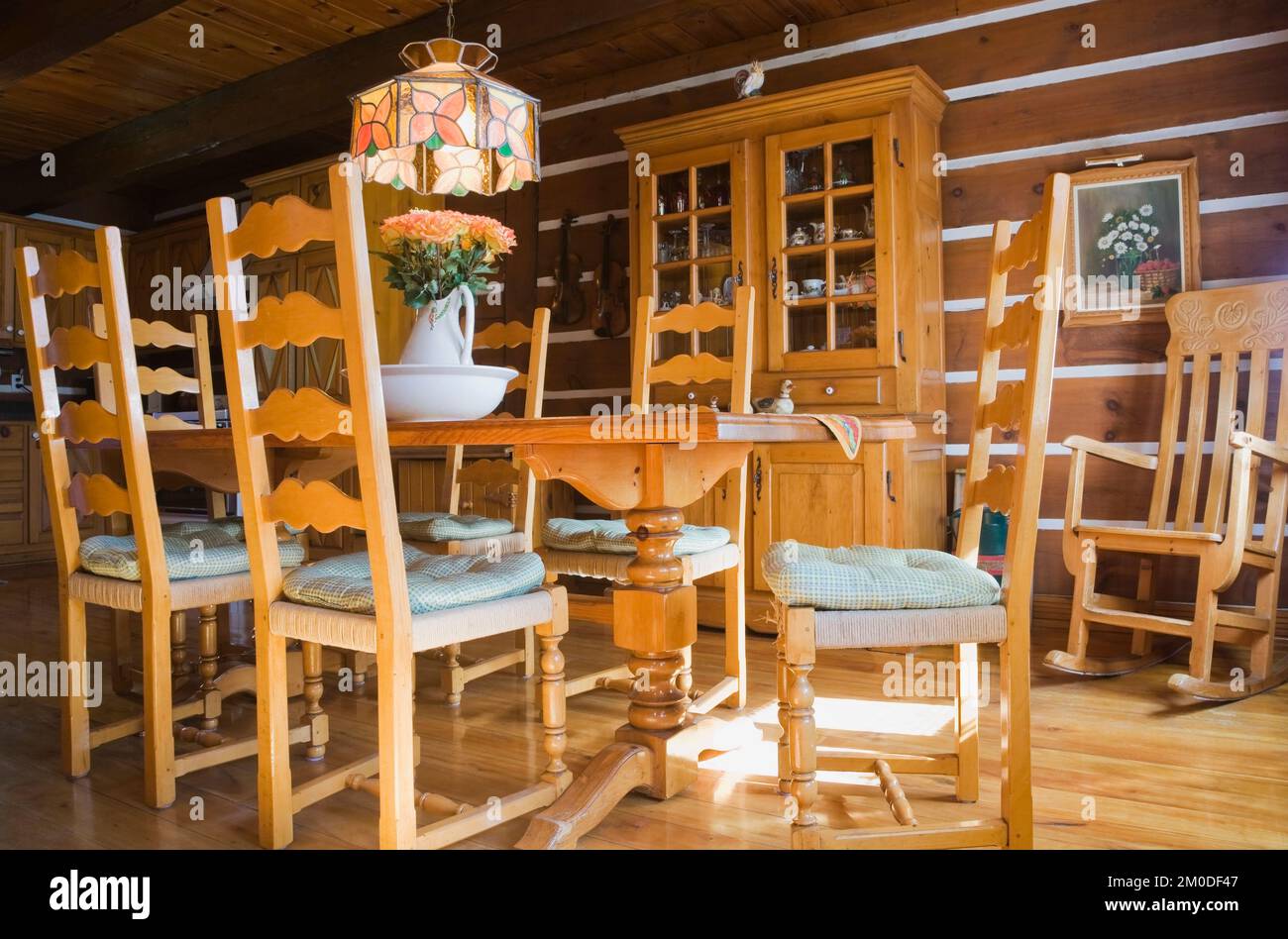 Chaises en bois de pin, table et meubles dans la salle à manger à l'intérieur de la maison en rondins de style cottage Canadiana. Banque D'Images