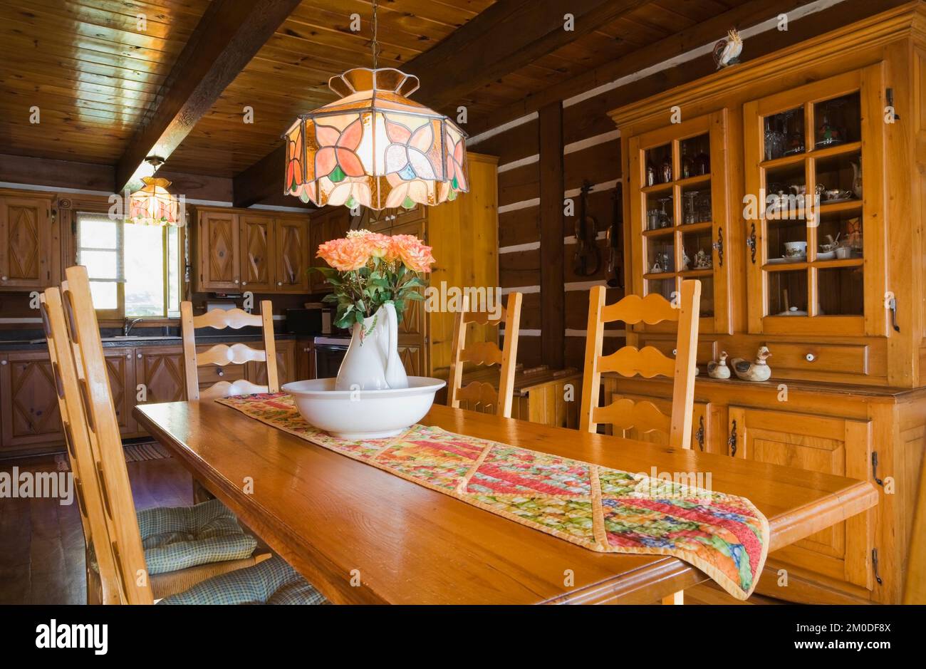 Chaises en bois de pin, table et meubles dans la salle à manger à l'intérieur de la maison en rondins de style cottage Canadiana. Banque D'Images