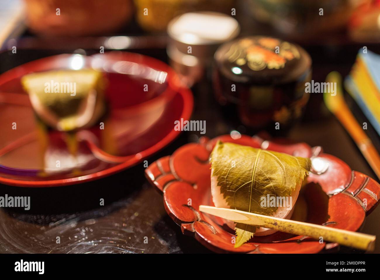 Mochi recouvert de feuilles servi sur un plat traditionnel japonais Banque D'Images