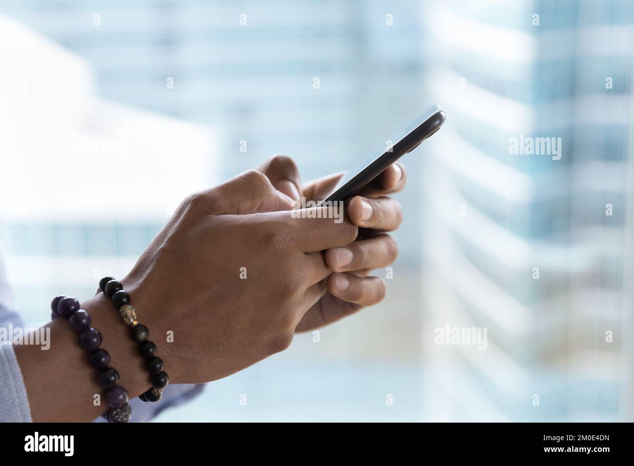 Téléphone portable dans les mains de sexe masculin gros plan vue latérale Banque D'Images