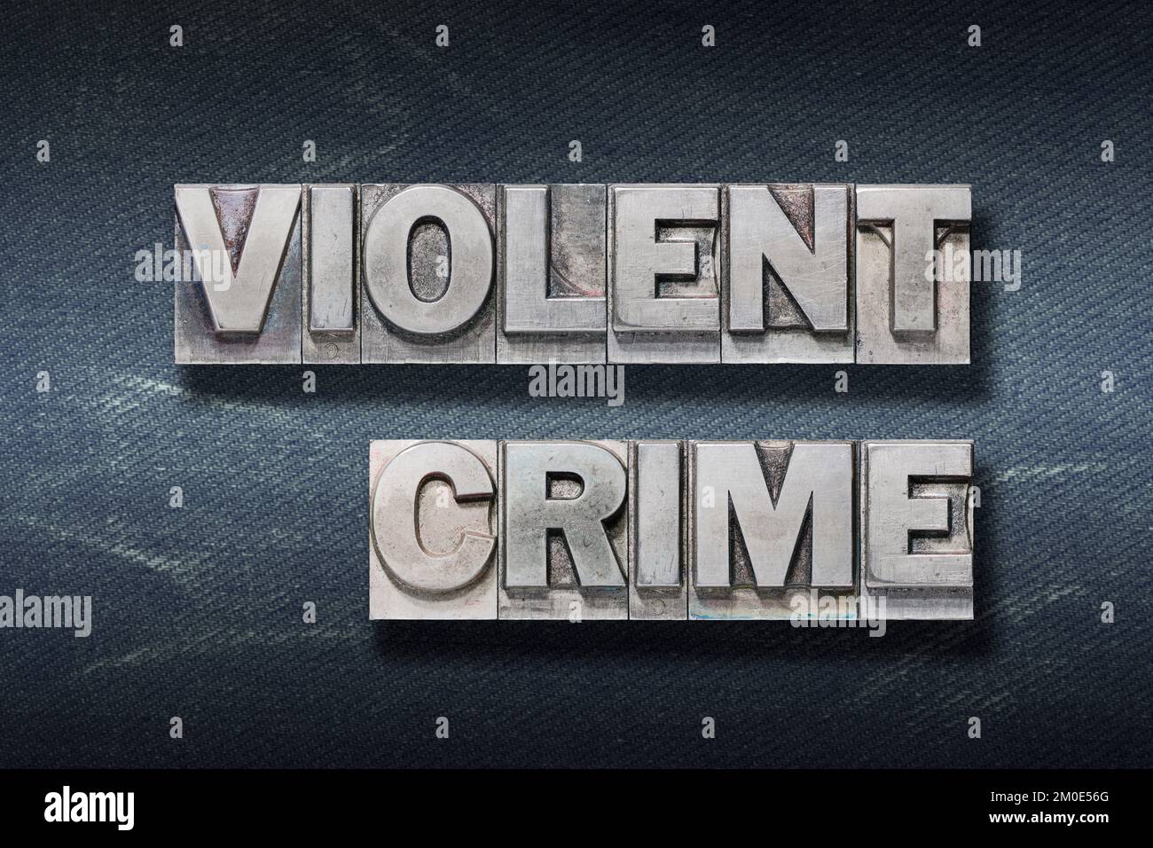 expression de crime violent faite de typographie métallique sur fond de jeans foncé Banque D'Images