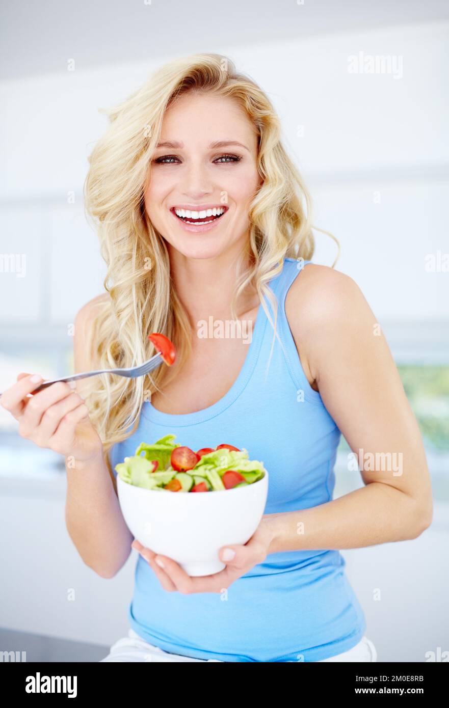 J'ai fait le choix sain. Jolie jeune femme souriant en tenant une salade. Banque D'Images