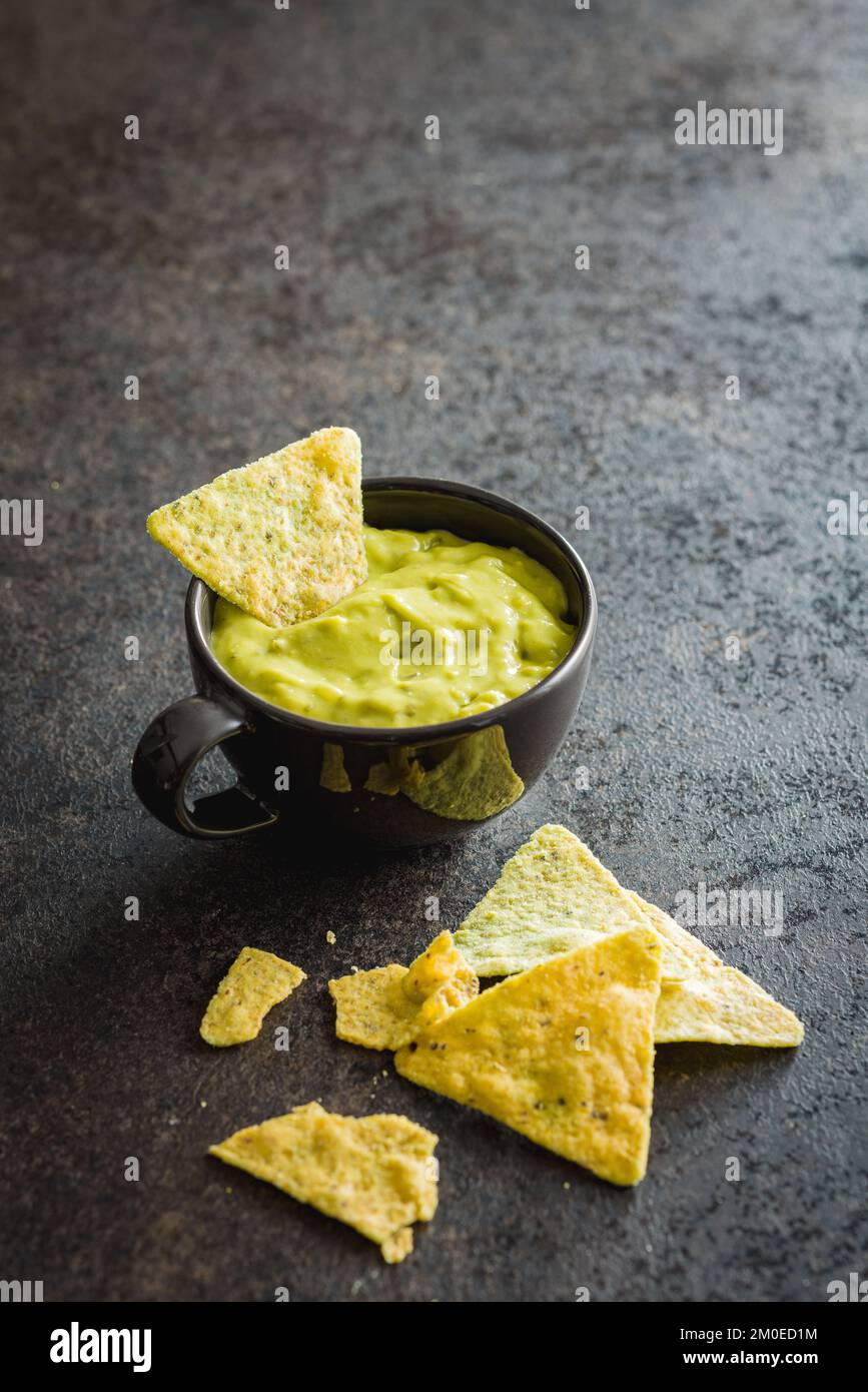 Croustilles tortilla avec la saveur de poivrons jalapeno et la salsa de guacamole. Banque D'Images