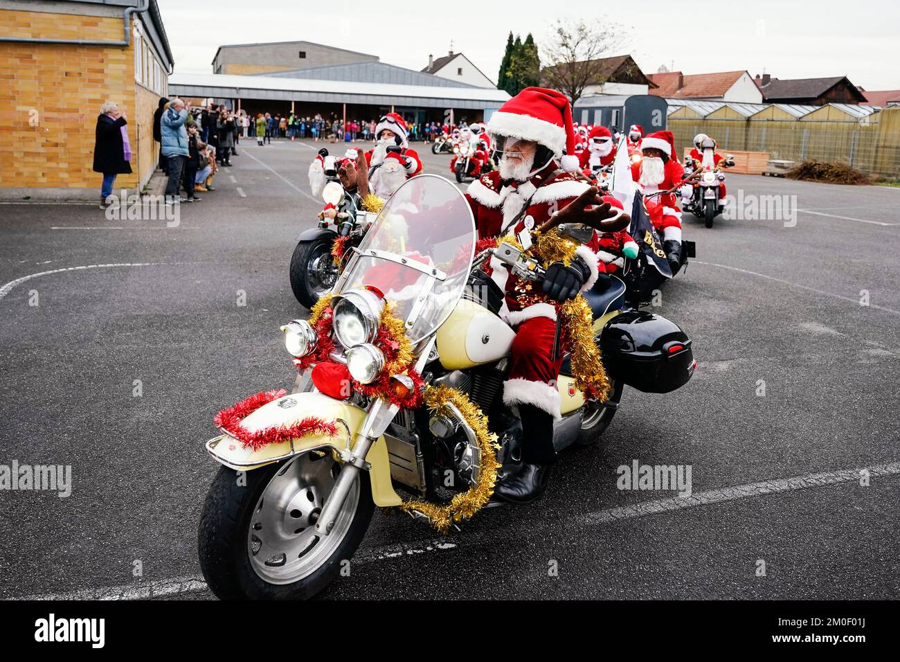 Kuhardt, Allemagne. 06th décembre 2022. Les motocyclistes habillés comme Santa Clasections passent leurs vélos dans une cour d'école. Les motocyclistes font une visite de collecte de fonds pour un hospice pour enfants dans le sud de la Rhénanie-Palatinat. L'année dernière, la 'Harley Davidson Riding Santas' a recueilli environ 105 000 euros. Credit: Uwe Anspach/dpa/Alamy Live News Banque D'Images