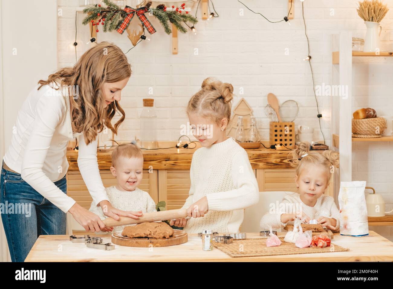 La mère et les filles du Caucase préparent des biscuits de Noël dans la cuisine. Banque D'Images