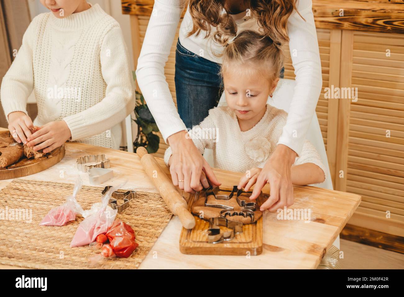 La mère et les filles du Caucase préparent des biscuits de Noël dans la cuisine. Banque D'Images