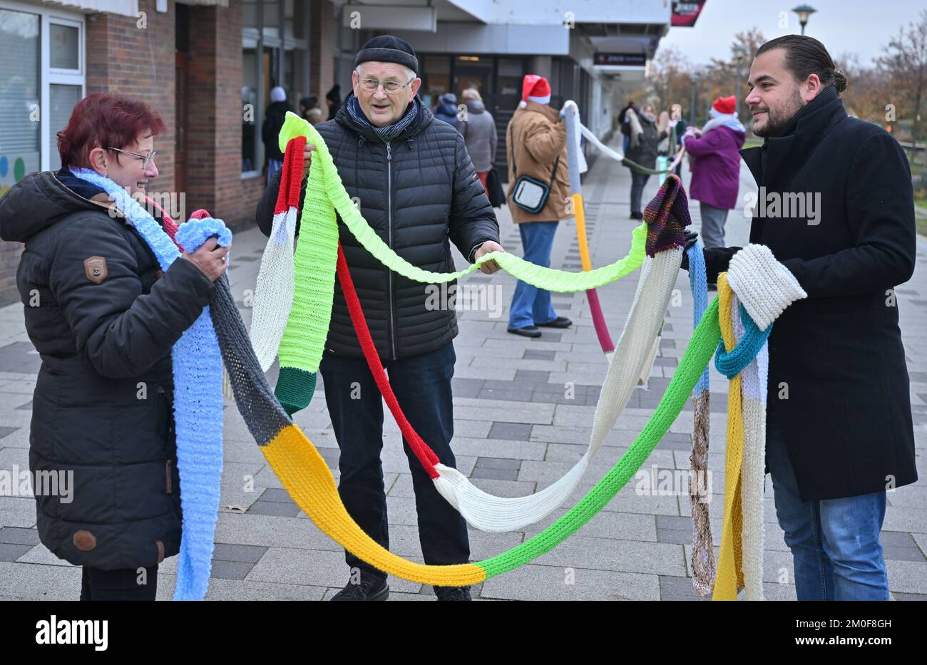 Cottbus, Allemagne. 06th décembre 2022. Les membres du Cottbus Left tiennent un foulard de 70 mètres de long de l'action "coudre contre le froid social". Le même jour, ils ont remis ce foulard au député du Bundestag Görke (Die Linke). Görke devait ensuite remettre le foulard au chancelier Scholz (SPD). Au cours des dernières semaines, les gauchistes du Cottbus ont tricoté une longue écharpe participative dans les espaces publics sur une base hebdomadaire. Le but de cette action symbolique était de critiquer la politique actuelle du gouvernement et d'engager des discussions avec les gens à ce sujet. Credit: Patrick Pleul/dpa/Alay Live News Banque D'Images