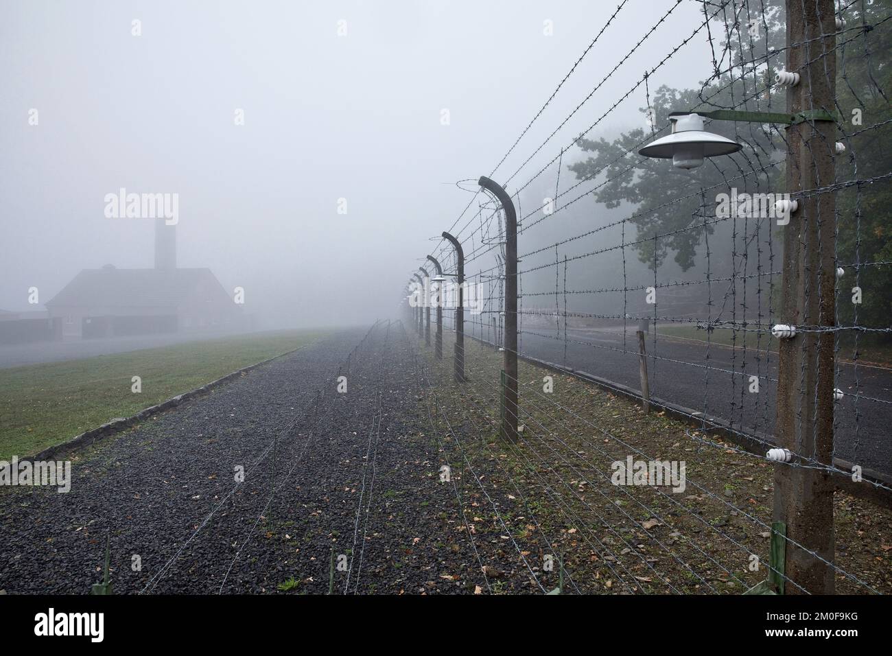 Une clôture de camp reconstruite avec un crématoire dans le brouillard dans le camp de concentration de Buchenwald, aujourd'hui un mémorial de camp de concentration, Allemagne, Thueringen, Banque D'Images