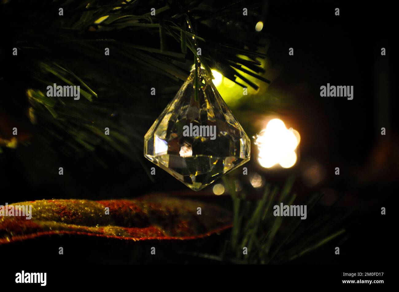 Décoration de sapin de Noël en verre avec décoration lumineuse d'étoile de Noël en arrière-plan Banque D'Images