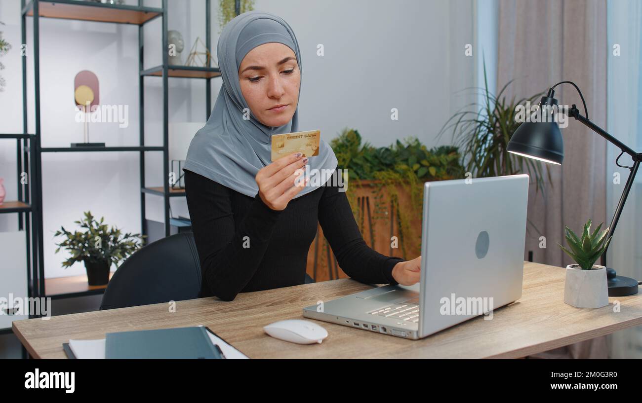 Femme d'affaires programmeur développeur de logiciels dans le travail hijab, faisant l'achat en ligne paiement achat avec carte de crédit et ordinateur portable à la maison bureau bureau avec ordinateur portable. Femme d'affaires indépendante musulmane Banque D'Images