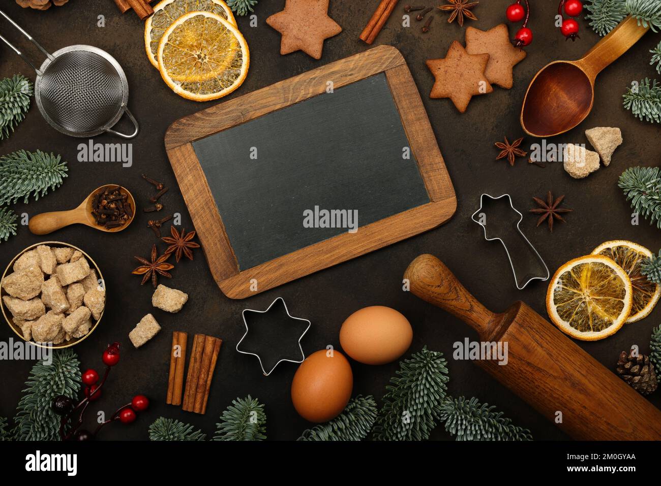 Affiche en gros plan noir vintage avec cadre en bois, décorations de Noël et ingrédients de la cuisine sucrée sur fond marron foncé avec Copy spa Banque D'Images