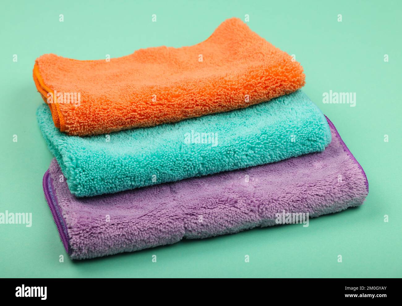 Pile de nouveaux vêtements et balais en microfibre doux et colorés pour le ménage, la vue en grand angle et les gros plans Banque D'Images