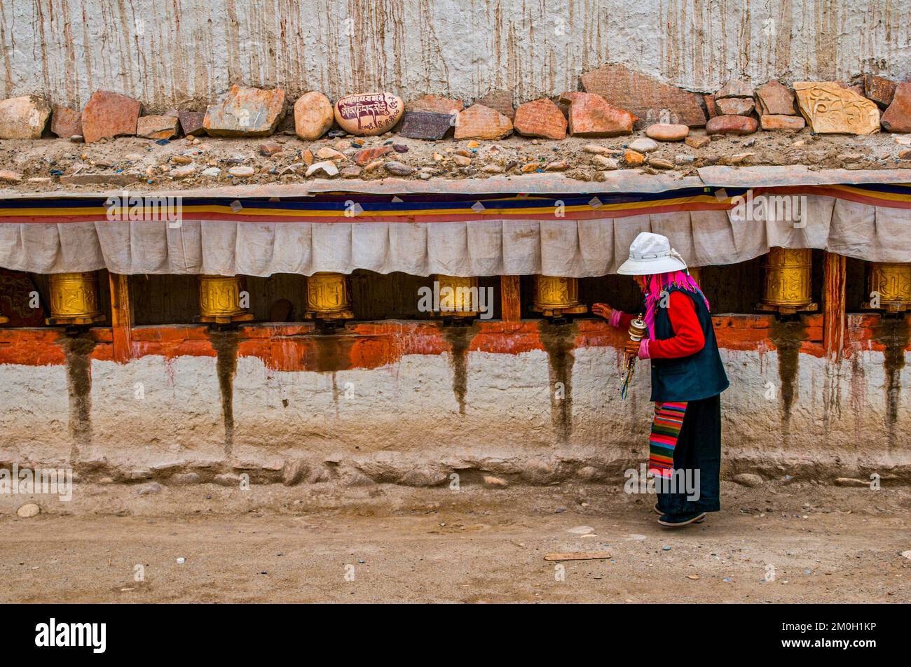 Vieille femme tournant les roues de prière dans le royaume de Guge, Tibet occidental, Asie Banque D'Images