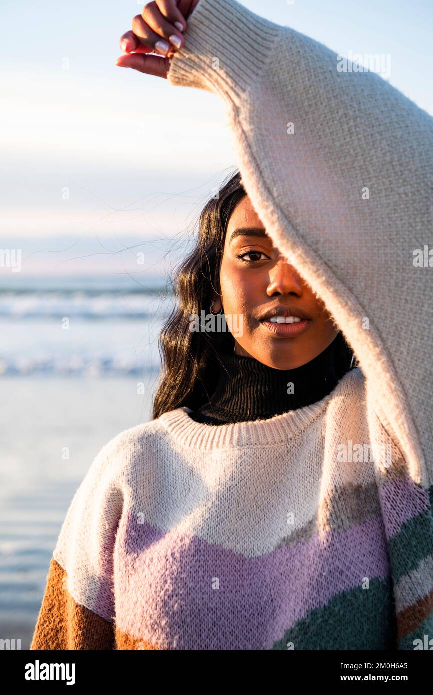 Portrait d'une jeune femme indienne à la plage regardant l'appareil photo Banque D'Images