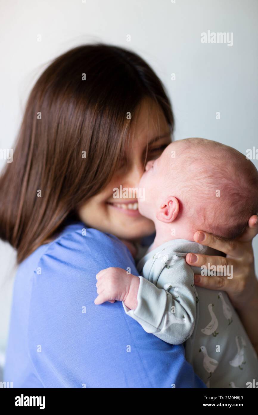 Gros plan de la mère heureuse tenant bébé à la maison Banque D'Images