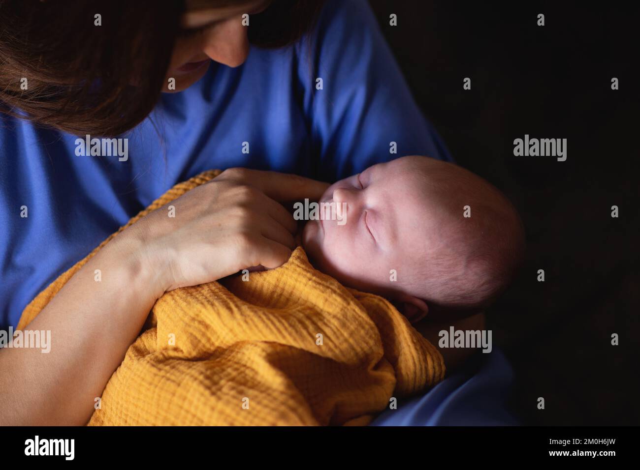 Une mère heureuse souriant à son nouveau-né alors qu'elle était dans les bras à la maison Banque D'Images