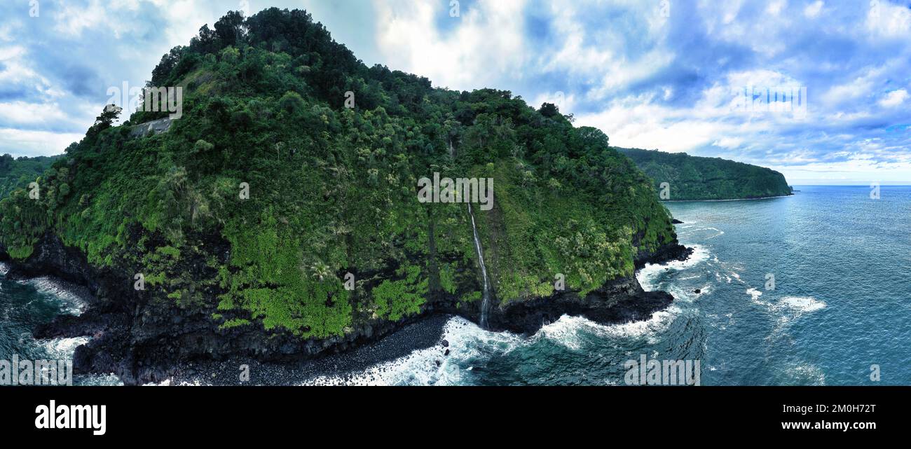 Une vue d'en haut met en évidence les environs pittoresques de Nua'ailua Stream Waterfall, y compris la plage de sable noir et les arbres verts luxuriants. Banque D'Images