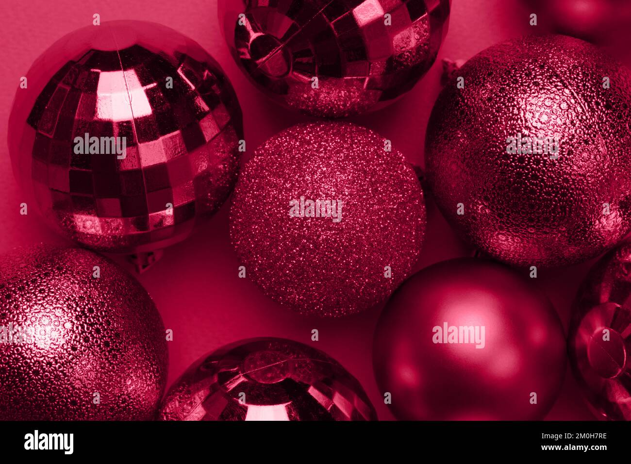 Carte de Noël avec boules brillantes viva magenta sur fond rouge carmin Banque D'Images