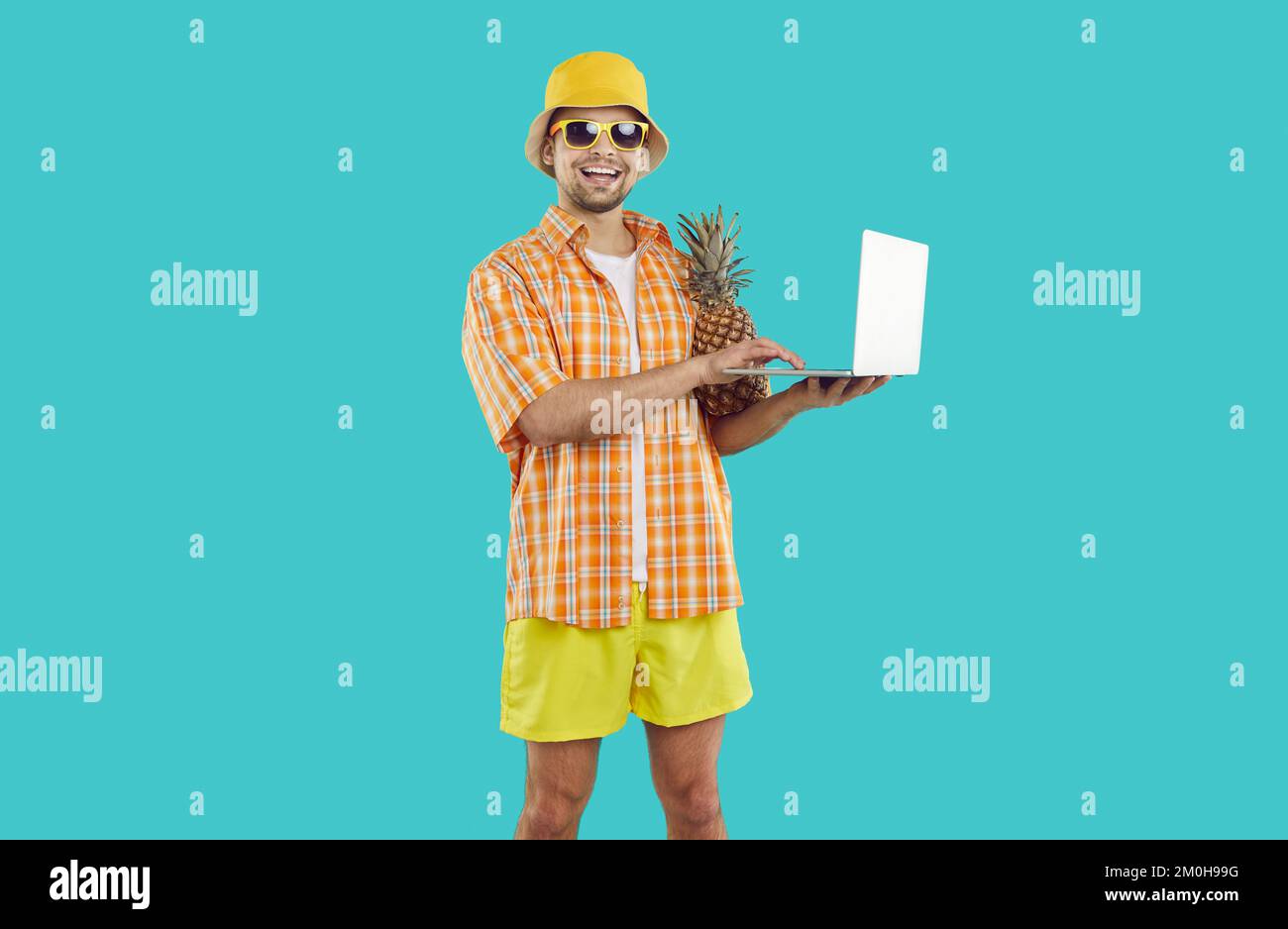 Portrait d'un homme joyeux qui utilise un ordinateur portable pour travailler en ligne ou apprendre à distance pendant les vacances d'été. Banque D'Images