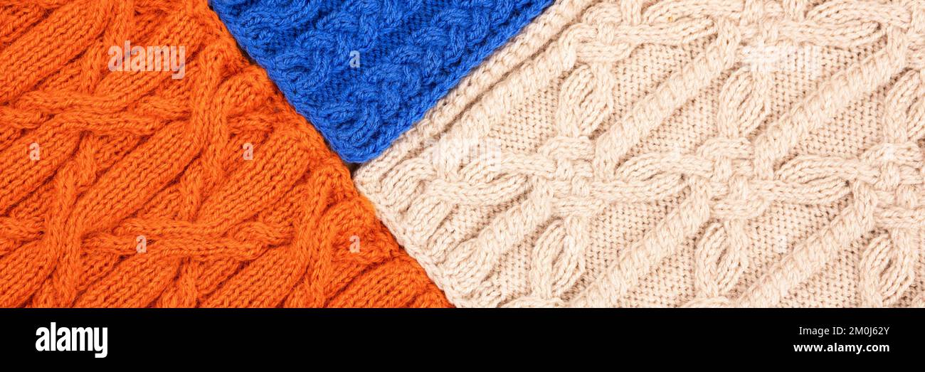 Fond bleu orange et beige. Grand tissu tricoté avec un motif. Gros plan d'une couverture tricotée. Bannière Banque D'Images