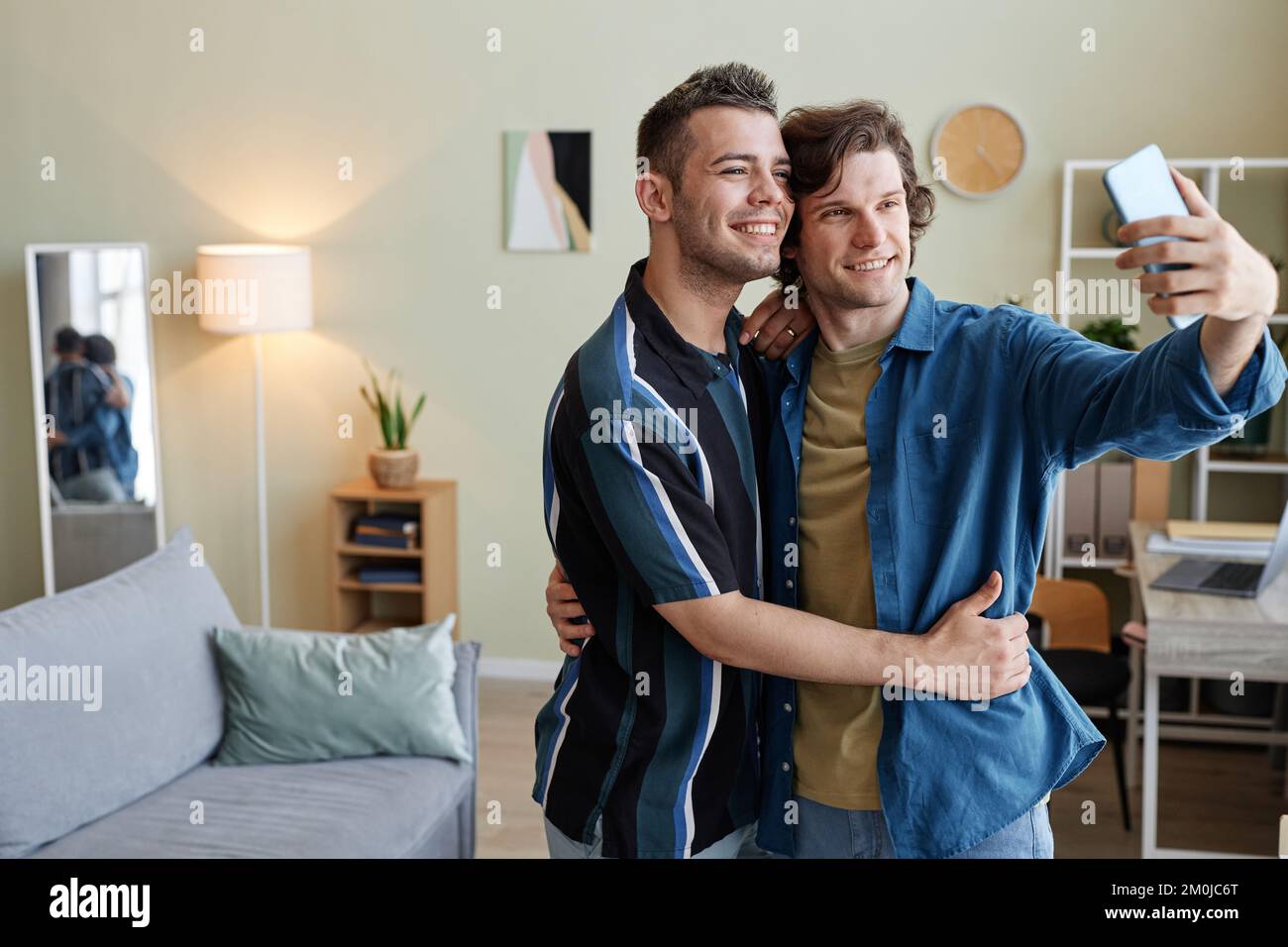 Portrait à la taille du jeune couple gay prenant la photo de selfie dans la nouvelle maison ensemble, espace de copie Banque D'Images