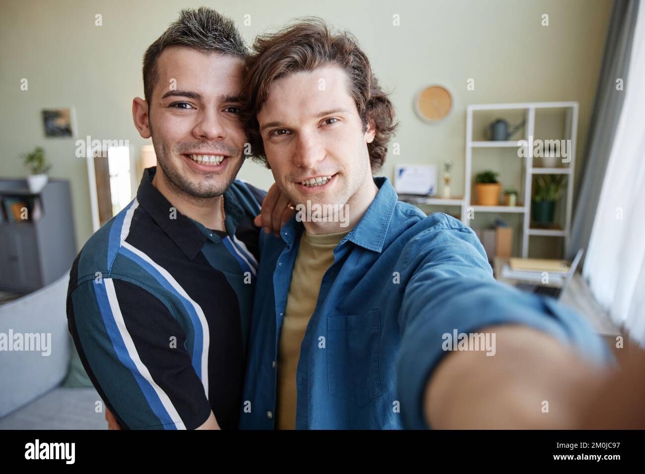 Portrait de jeune couple gay prenant photo selfie dans la nouvelle maison ensemble, caméra POV Banque D'Images