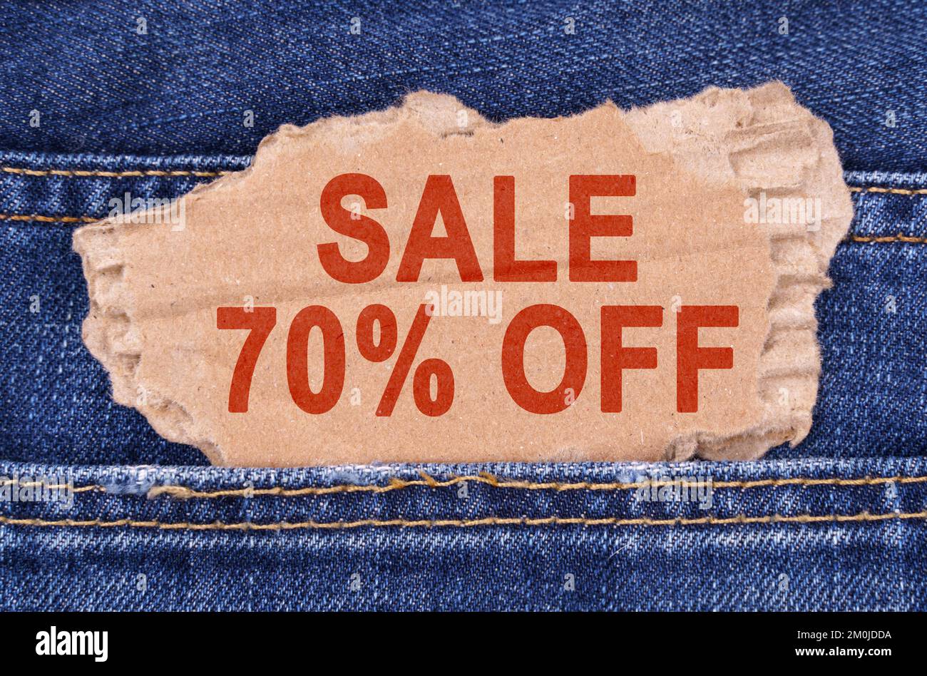 Affaires et finances. Une boîte en carton avec l'inscription - SOLDE 70 bâtonnets de jeans. Banque D'Images