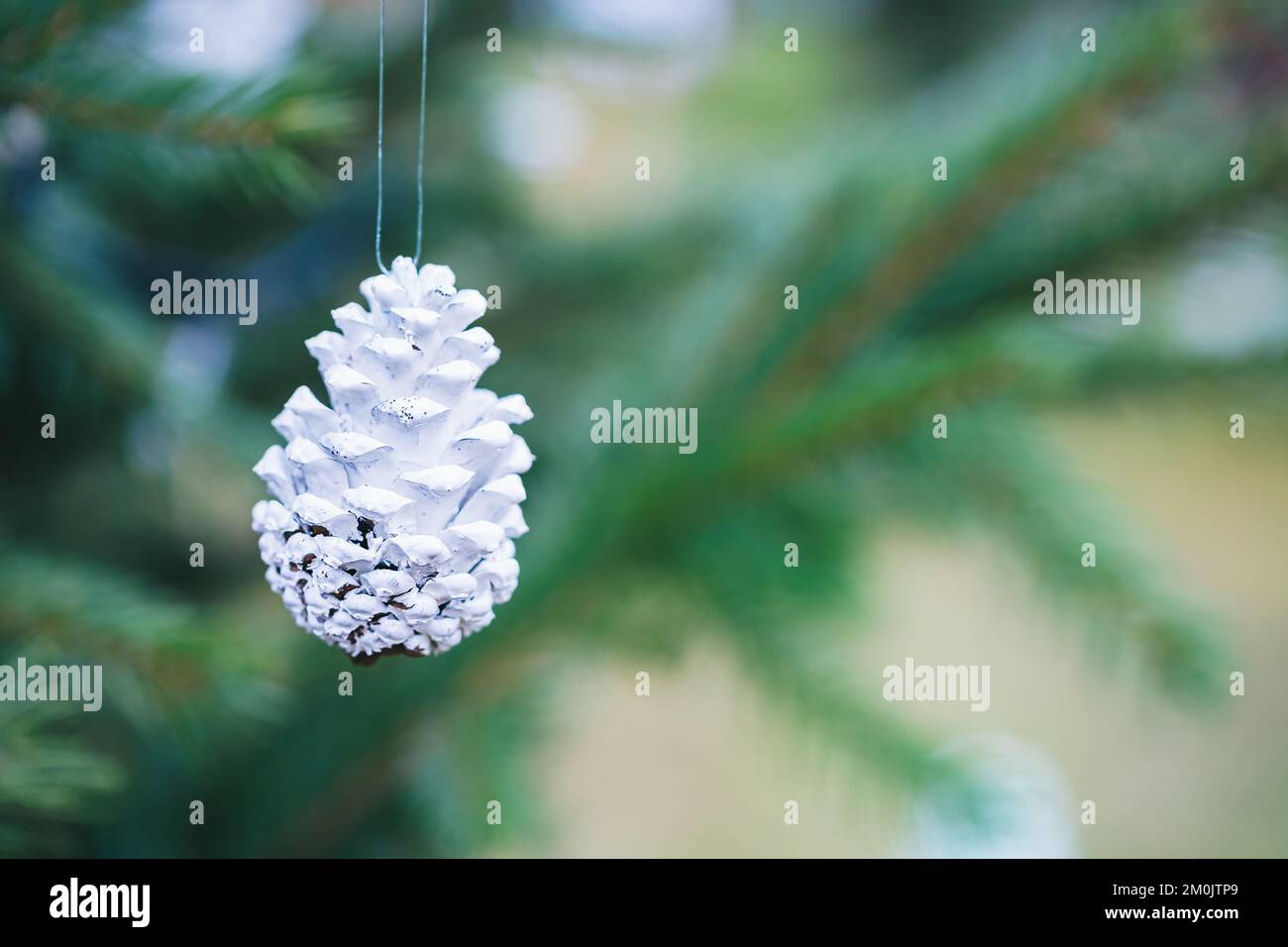 Cône de pin peint en blanc sur l'arbre de Noël. Idées de décoration
