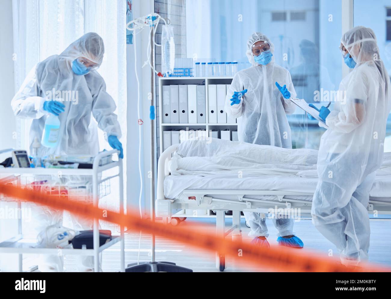 Collègues présentant un risque biologique qui parlent de corps morts à l'hôpital. Les médecins lisant le rapport sur le corps mort de covid. Les scientifiques discutent du papier sur le presse-papiers à propos de Banque D'Images