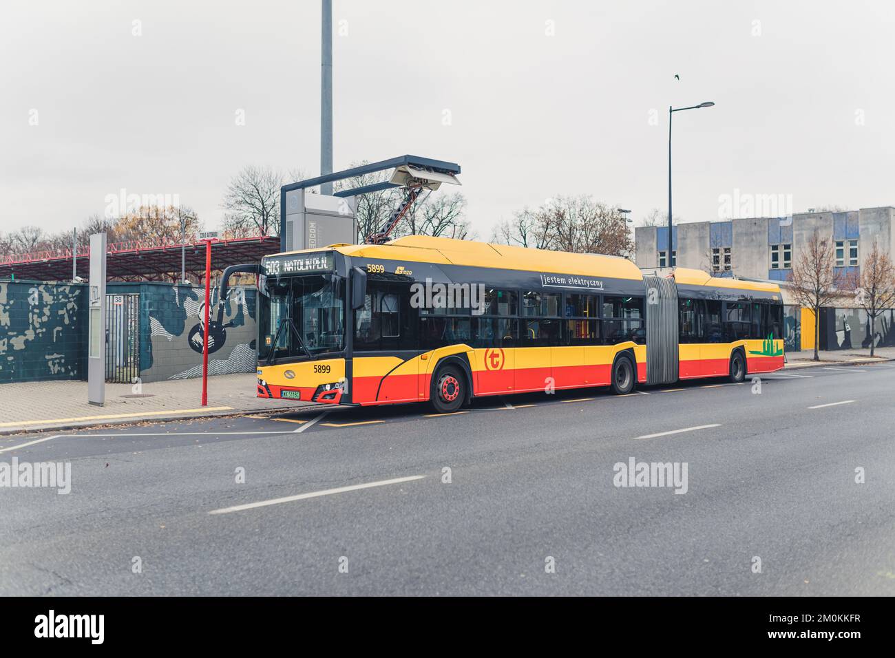 11.17.2022 Varsovie, Pologne. Plein air de plein air de bus moderne à Varsovie étant chargé par le chargeur de bus électrique. Ciel gris. Photo de haute qualité Banque D'Images