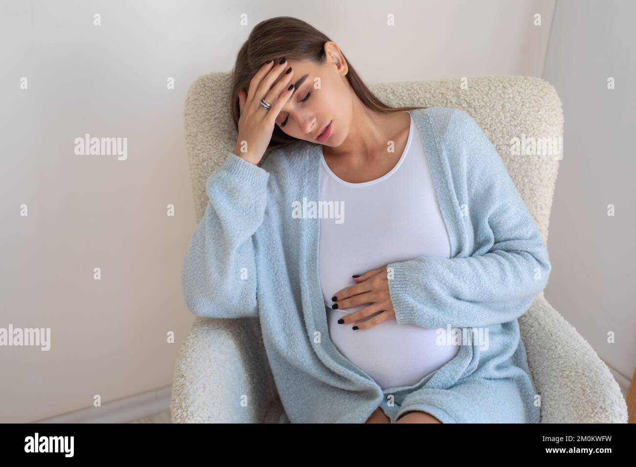 Jeune femme enceinte ayant un mal de tête Banque D'Images