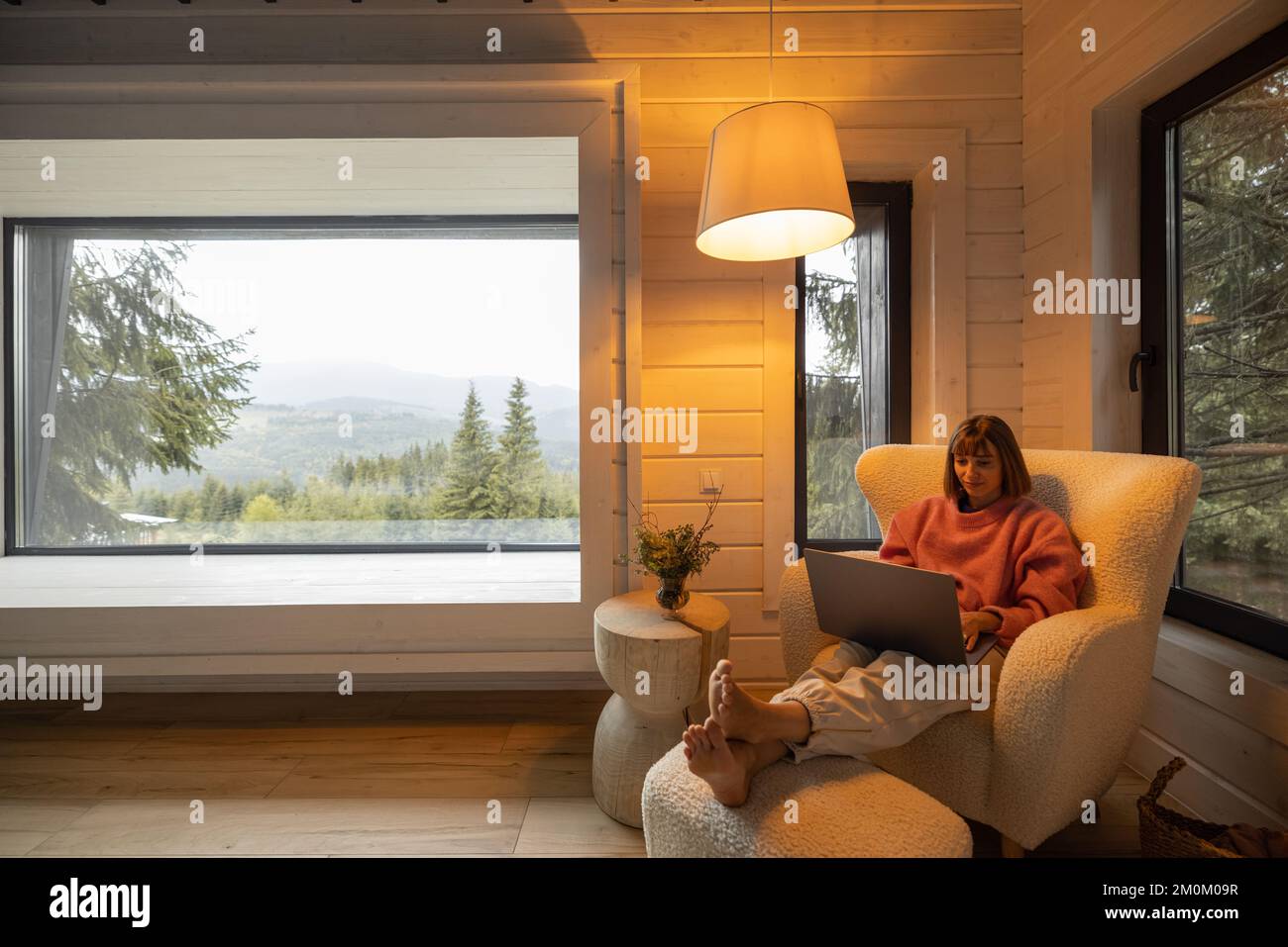 Femme travaille sur ordinateur portable à la maison dans les montagnes Banque D'Images