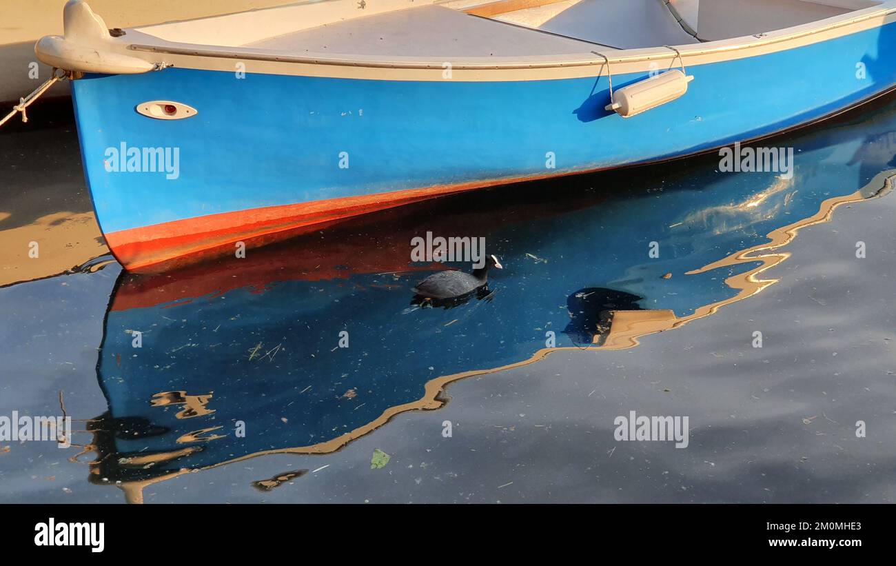 un petit bateau se reflète à la surface de la mer Banque D'Images