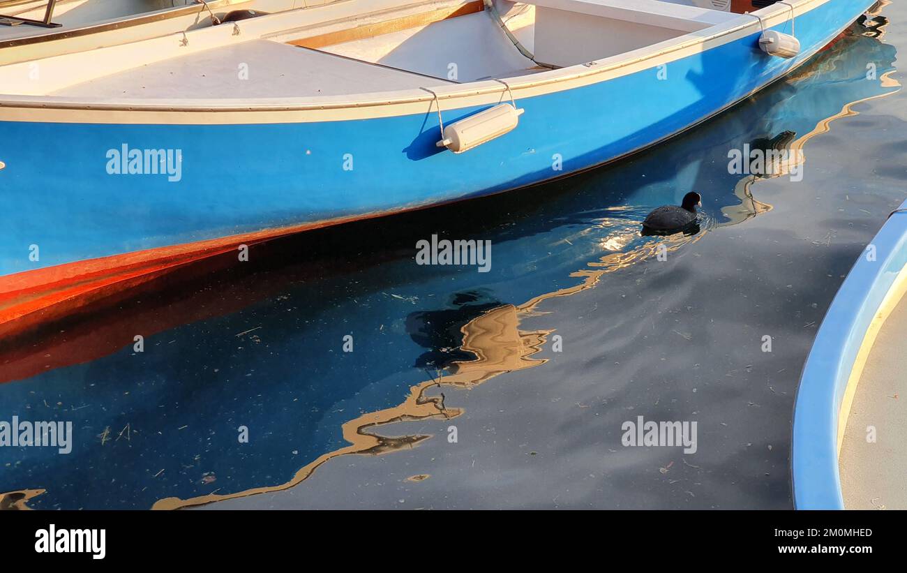 un petit bateau se reflète à la surface de la mer Banque D'Images