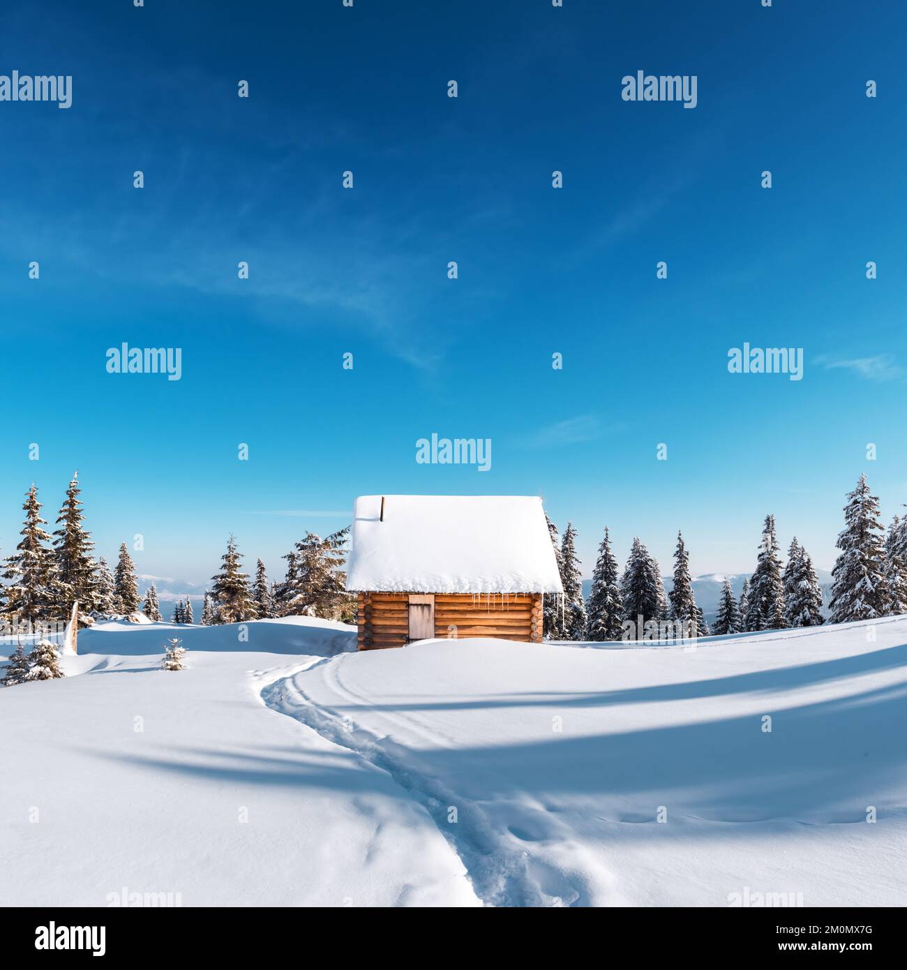 Paysage d'hiver fantastique avec maison en bois dans les montagnes enneigées. Ciel bleu profond clair. Concept de vacances de Noël. Montagne des Carpates, Ukraine, Europe Banque D'Images