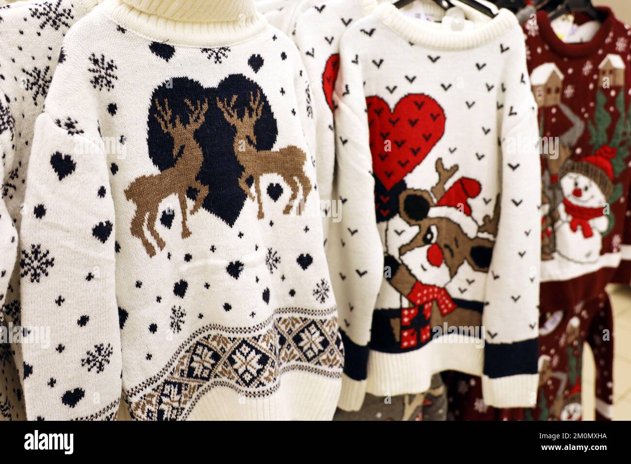 Sweaters tricotés avec motif de Noël dans un magasin.Tenue traditionnelle et chaleureuse pour les fêtes du nouvel an Banque D'Images