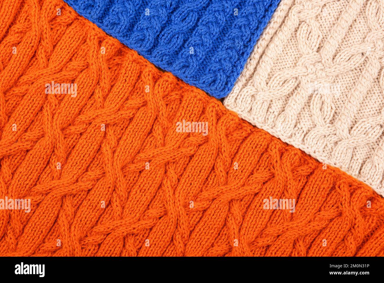 Fond bleu orange et beige. Grand tissu tricoté avec un motif. Gros plan d'une couverture tricotée. Banque D'Images