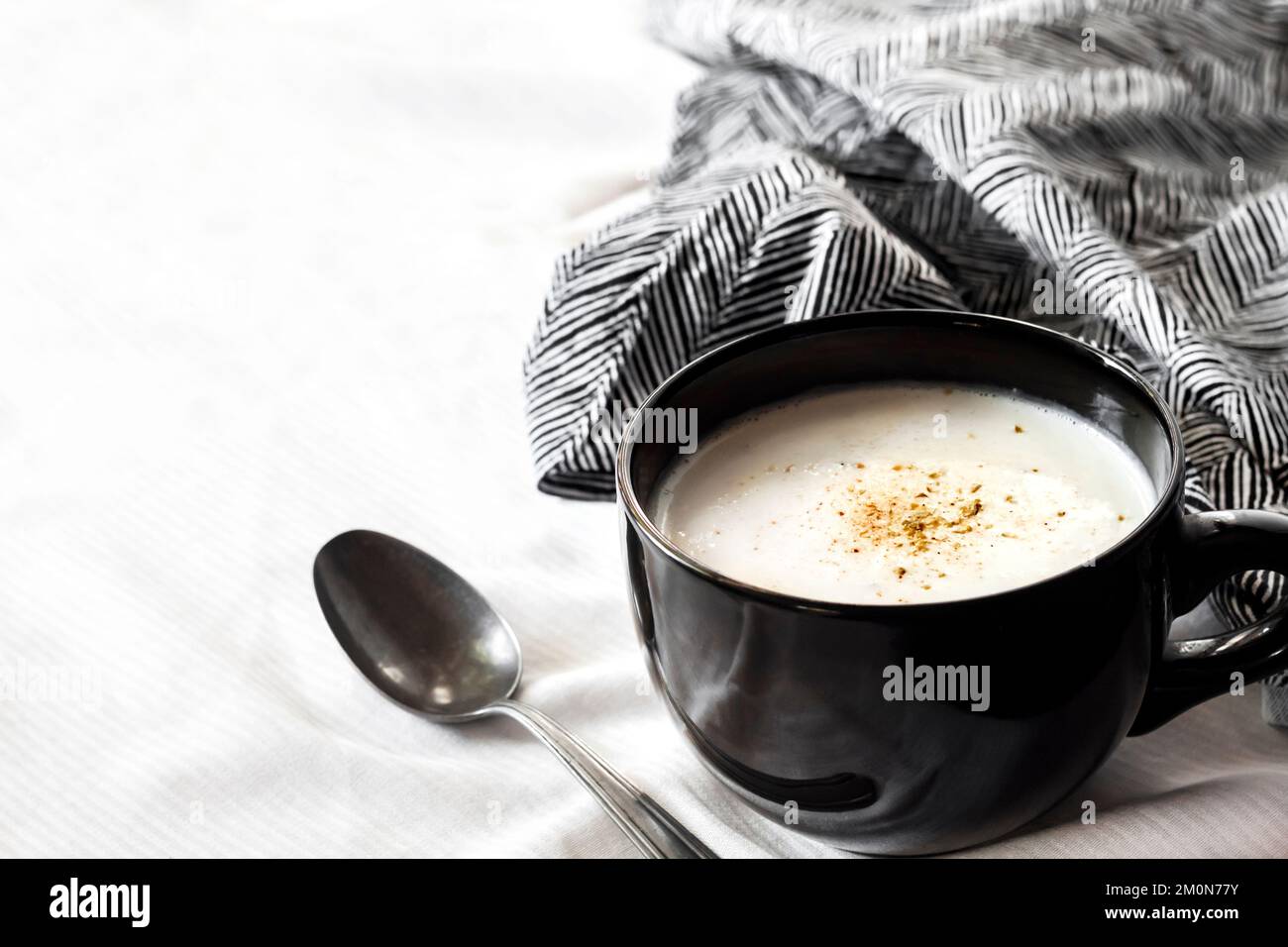 Soupe de chou-fleur (crème du Barry) dans un bol noir sur fond blanc avec tissu noir et blanc. Copier l'espace Banque D'Images Soupe de chou-fleur (crème du Barry) dans un bol noir sur fond blanc avec tissu noir et blanc. Copier l'espace Banque D'Images