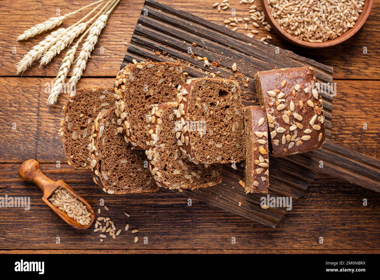 Pain de seigle de grain entier avec des graines coupées en tranches de pain sur bois, vue de dessus Banque D'Images