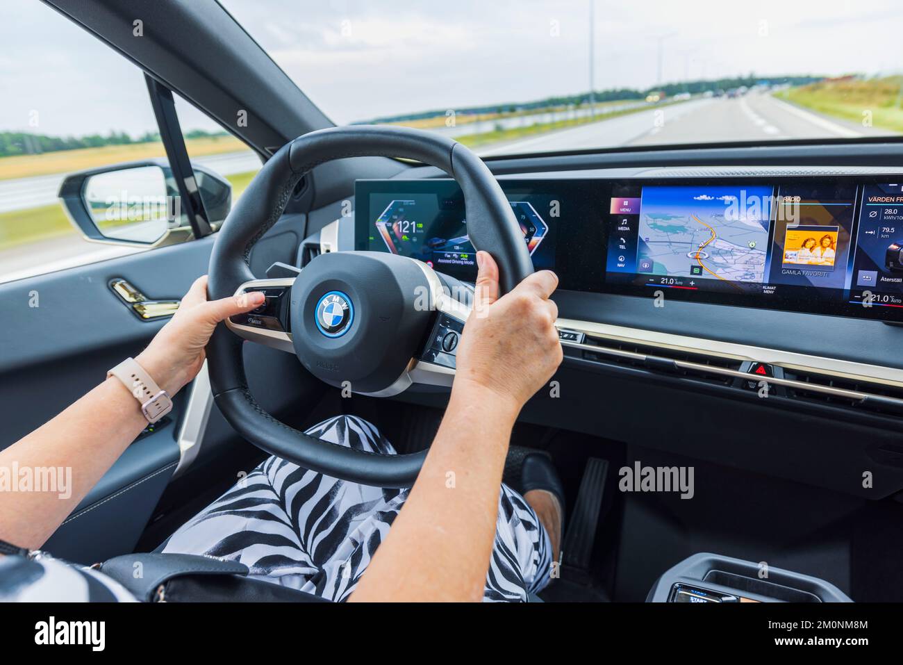 Vue rapprochée d'une femme conduisant une nouvelle voiture électrique BMW IX 40. Suède. Uppsala. Banque D'Images