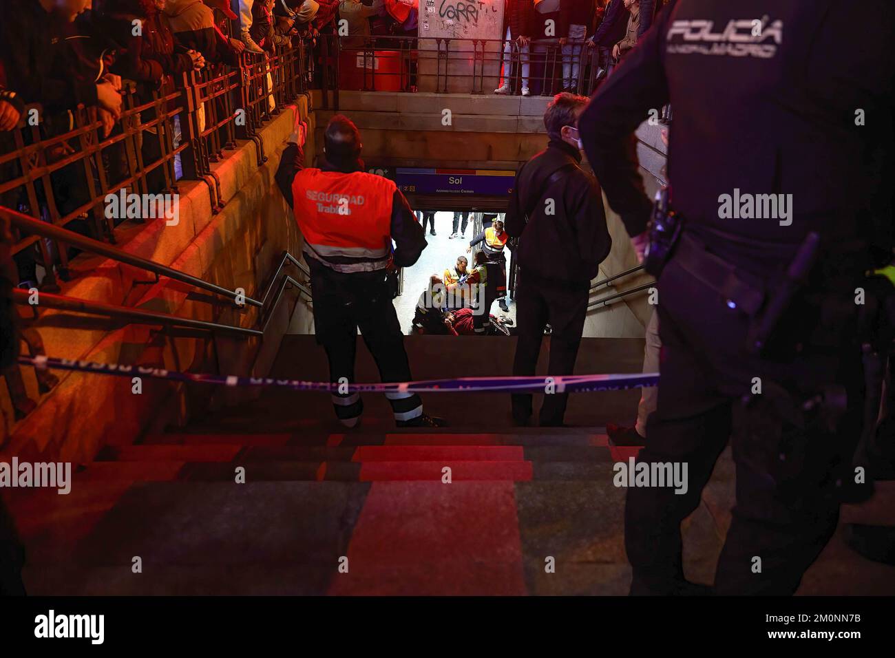 Une personne blessée est traitée par un personnel médical après être tombée d'une garde-corps tout en célébrant la victoire du Maroc. Des centaines de personnes se rassemblent dans les rues du centre de Madrid pour célébrer la victoire du Maroc sur l'Espagne. Banque D'Images