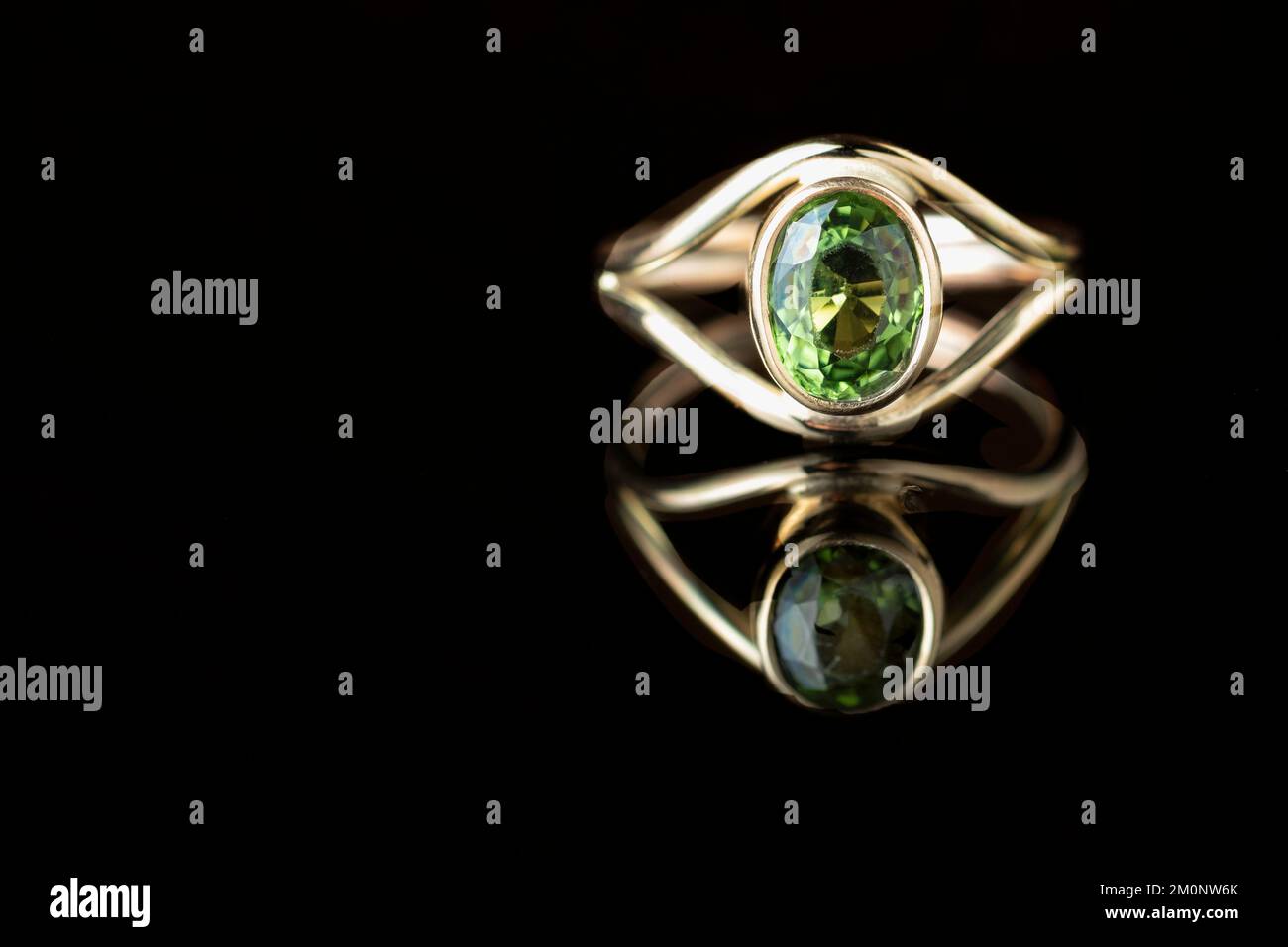 Une femme fait à la commande bague d'or fait à la main par un artisan de bijoux. Une grande pierre en cristal vert tourmaline est montée dans l'anneau. Banque D'Images