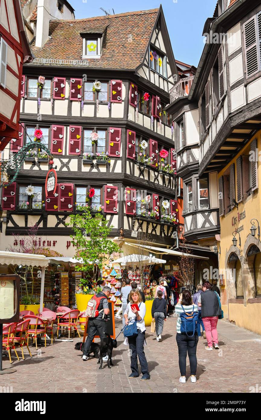 Colmar, France - avril 2022 : personnes dans l'une des rues étroites des bâtiments anciens décorés dans le centre de Colmar Banque D'Images