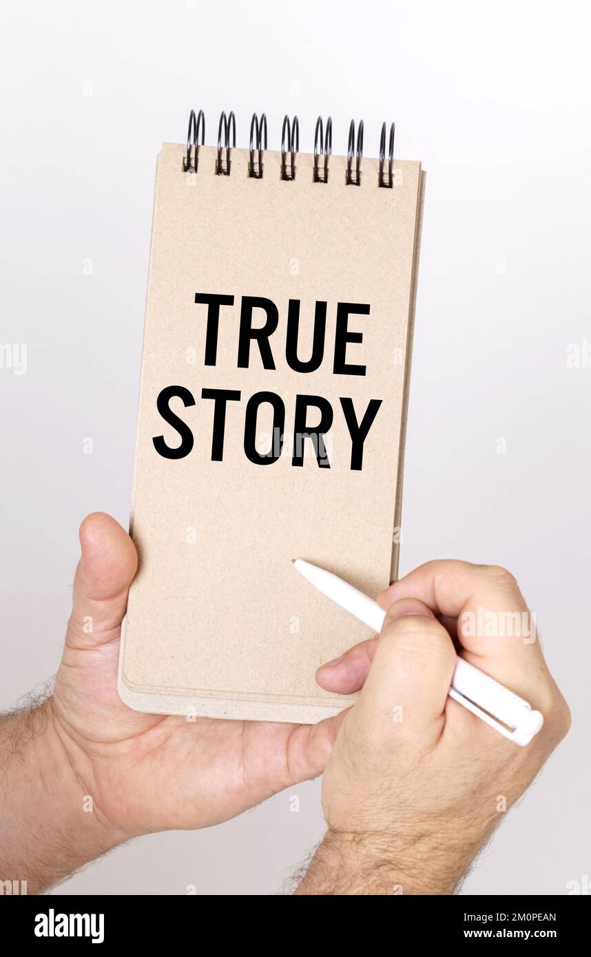 Concept commercial et financier. Un homme tient un stylo et un nœud dans ses mains avec l'inscription - True Story Banque D'Images