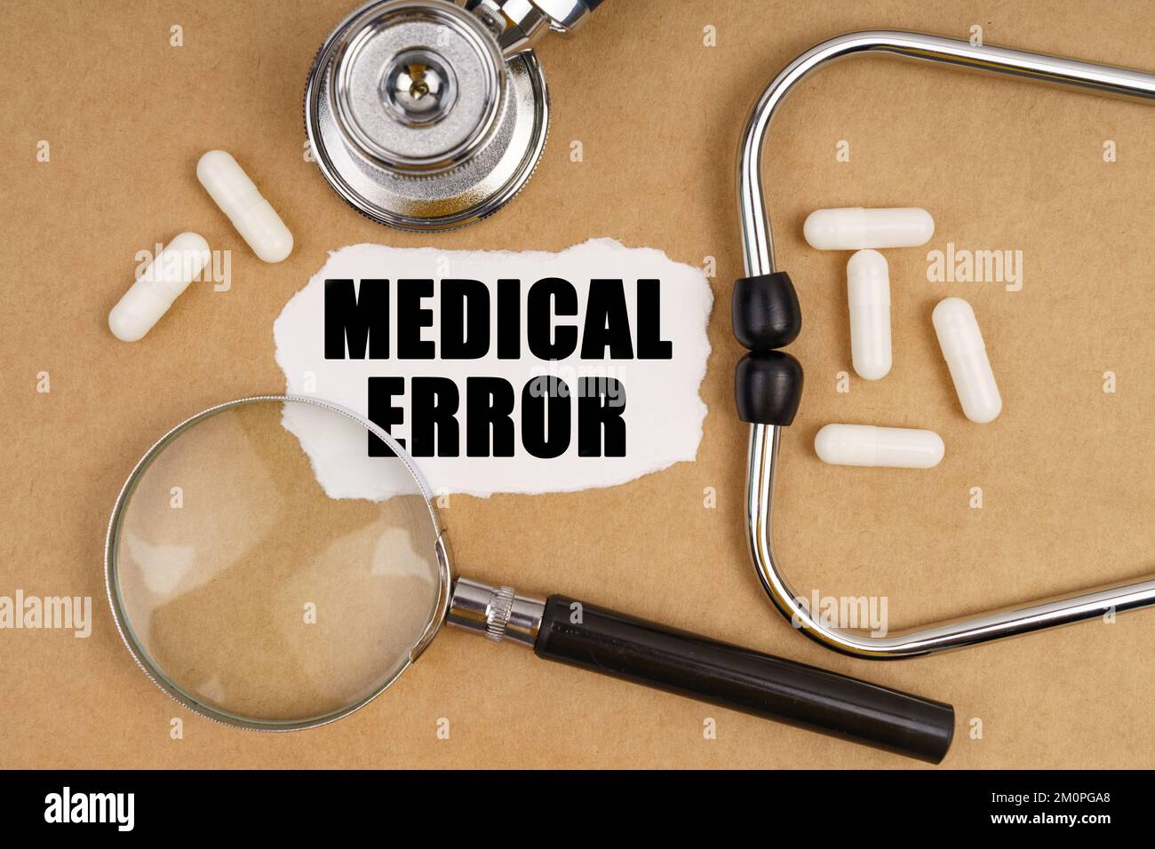 Médecine et concept de santé. Sur la table se trouve un stéthoscope, des  pilules, une loupe et du papier avec l'inscription - ERREUR MÉDICALE Photo  Stock - Alamy