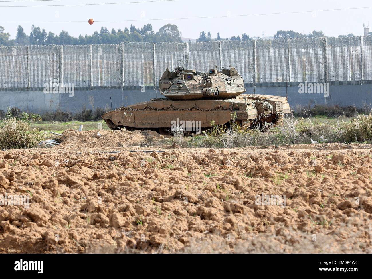 Gaza, Palestine. 07th décembre 2022. Un char de combat israélien Merkava est stationné près des excavatrices et des bulldozers israéliens qui démolissent les vestiges du passage commercial de Karni près de la frontière de Gaza, alors qu'Israël décidait d'étendre une barrière de sécurité à l'emplacement du terminal de longue date. (Photo par Ahmed Zakot/SOPA Images/Sipa USA) crédit: SIPA USA/Alay Live News Banque D'Images